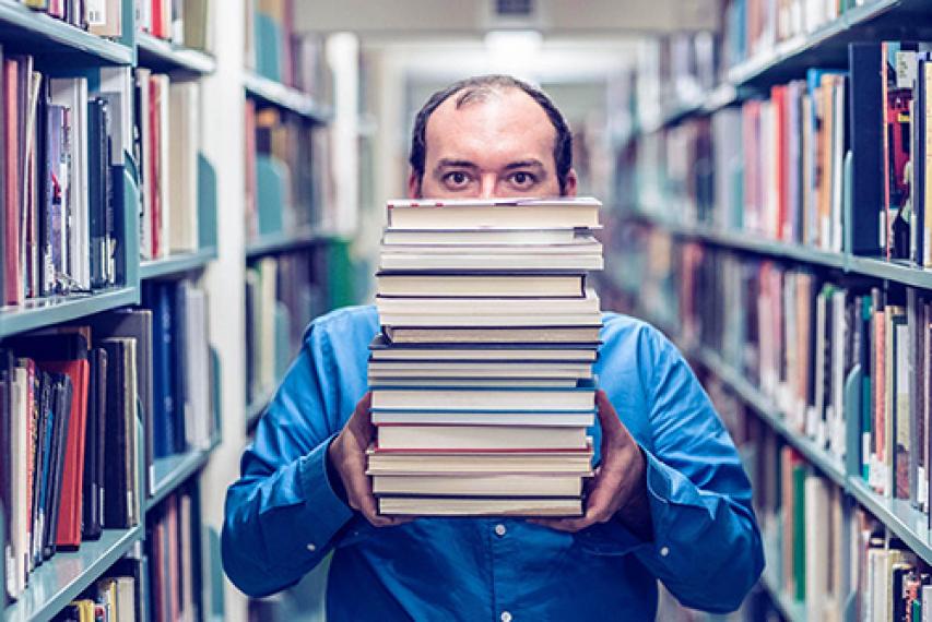 Student holds stack of library books